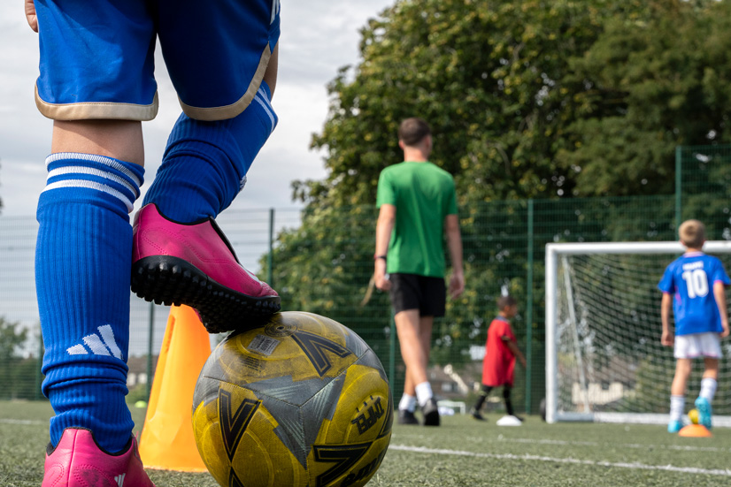 Young people playing football on a pitch