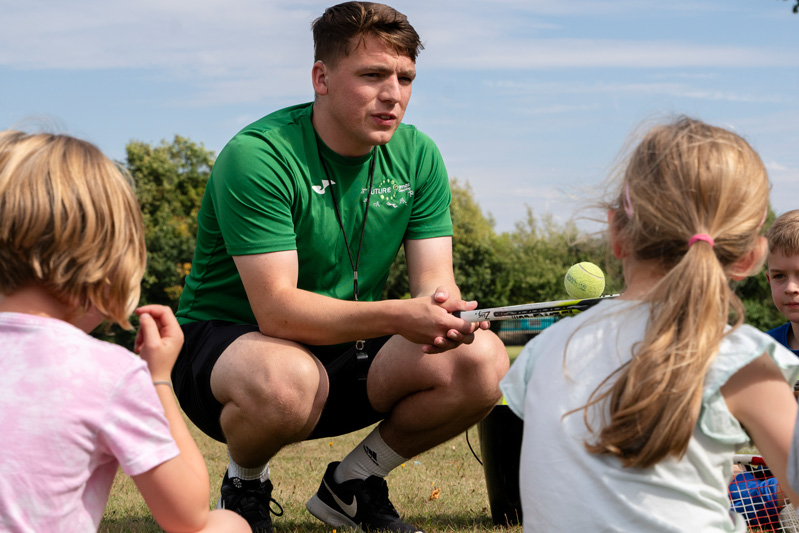 A coach kneeling beside children