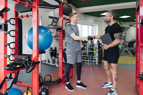 A personal trainer making an exercise plan for a young man